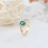 a gold ring with a green stone and diamonds