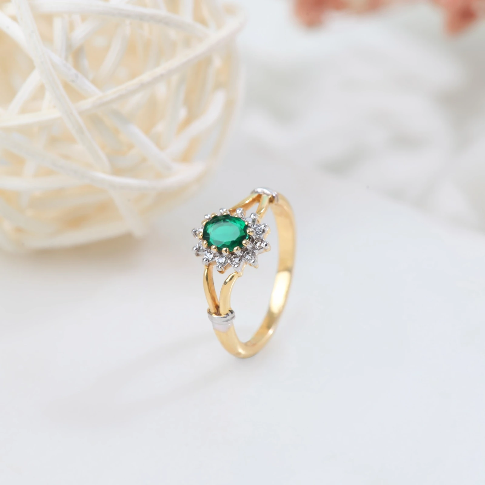 a gold ring with a green stone and diamonds